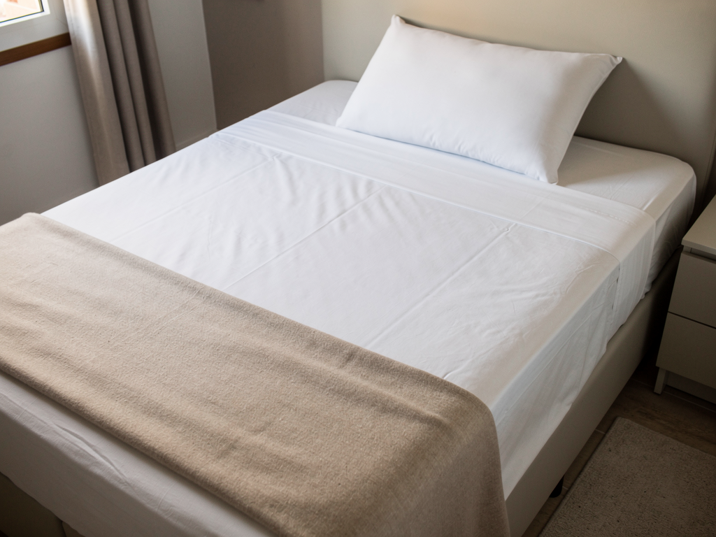 Almohada genérica de espuma de supermercado sobre una cama matrimonial