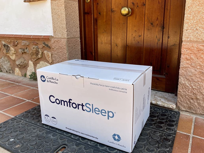 Caja del producto ComfortSleep en la puerta de entrada de una casa de pueblo española