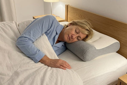Dormir de lado con el cuello apoyado en el reborde gris de la almohada ComfortSleep