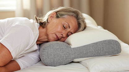 Persona durmiendo de lado sobre almohada cervical con lados elevados y columna en linea recta