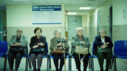 Sala de espera de ambulatorio público español con personas mayores sentadas