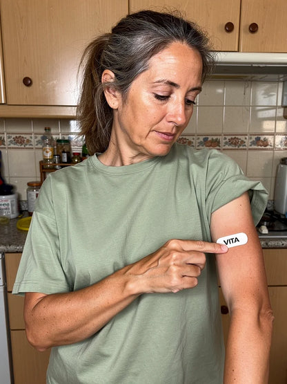 Mujer de 55 anos pegandose el parche VITA en el antebrazo